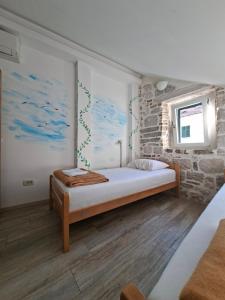 ein Schlafzimmer mit einem Bett in einer Ziegelwand in der Unterkunft CENTRUM HOSTEL in Kotor