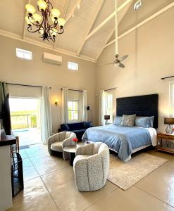 a bedroom with a bed and two chairs and a couch at Grand View Cottages - 2 King Suites - Entire Cottage in Riebeek-Kasteel +53 photos
