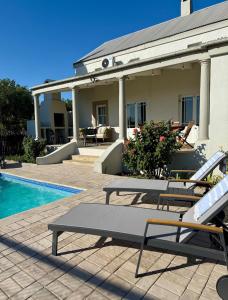 a house with a patio and a swimming pool at Grand View Cottages - 2 King Suites - Entire Cottage in Riebeek-Kasteel