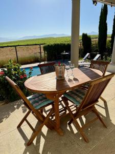 a wooden table with four chairs around it on a patio at Grand View Cottages - 2 King Suites - Entire Cottage in Riebeek-Kasteel