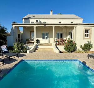 a house with a swimming pool in front of a house at Grand View Cottages - 2 King Suites - Entire Cottage in Riebeek-Kasteel