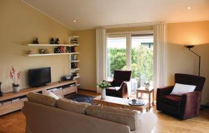 a living room with a couch and chairs and a tv at Seehund 102 in Sint Annaland