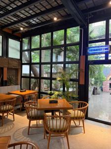 a restaurant with tables and chairs and large windows at Hamsun Shahrah-e-Faisal in Karachi