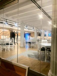 a dining room with white tables and white chairs at Azure Bay Resort in Sarandë