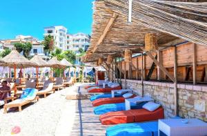 a row of lounge chairs and umbrellas on a beach at Azure Bay Resort in Sarandë