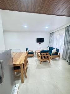 a living room with a table and chairs and a tv at HB Apartment in Thimphu in Thimphu +5 photos