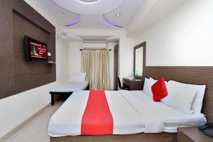 um quarto com uma cama grande e almofadas vermelhas em Hotel MB International em Mysore