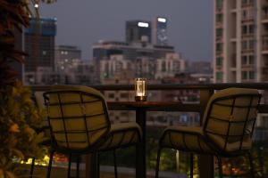 two chairs and a table with a candle on a balcony at EVEN Hotel Shenzhen Nanshan by IHG in Shenzhen