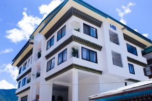 a white building with blue skies in the background at HB Apartment in Thimphu in Thimphu