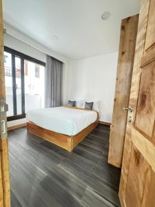 a bedroom with a bed and a wooden door at HB Apartment in Thimphu in Thimphu