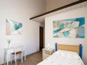 a bedroom with a bed and a desk and a painting at La Piazzetta in Goito