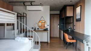 a loft apartment with a staircase and a living room at Lush inn Phuket in Ban Suan