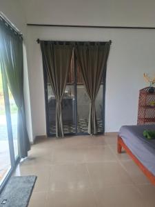a living room with a door with curtains at Zen Space Nesat in Phumĭ Chroŭy Svay