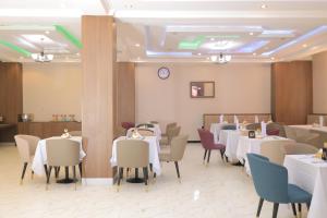 a restaurant with tables and chairs and a clock on the wall at History Hotel in Dirē Dawa