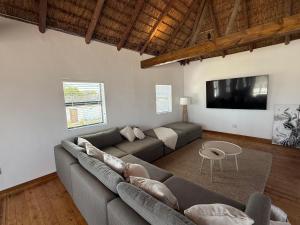 a living room with a couch and a flat screen tv at Old Harbour Place in Gansbaai