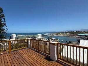 a wooden deck with a view of the water at Old Harbour Place in Gansbaai