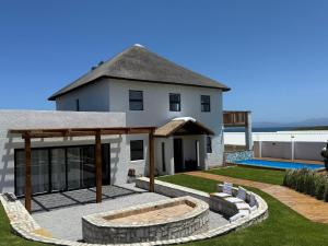a house with a patio and a swimming pool at Old Harbour Place in Gansbaai