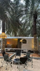 a group of chairs sitting in front of a train at Hidden Valley GLAMPING in Fujairah