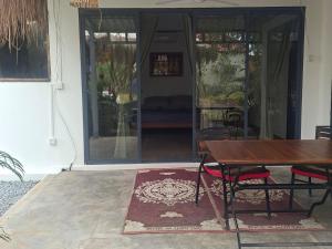 a table and chairs in front of a door at Zen Space Nesat in Phumĭ Chroŭy Svay