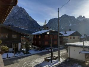 a building with a snow covered mountain in the background at Casa Milpa in Sappada