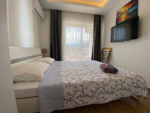 a bedroom with a bed with a tv on the wall at Orange&Lemon Villas Çamyuva in Kemer