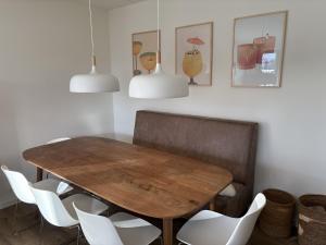 a dining room with a wooden table and white chairs at Waddenvilla 7 in Hollum