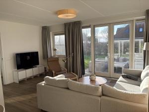 a living room with a couch and a tv at Waddenvilla 7 in Hollum
