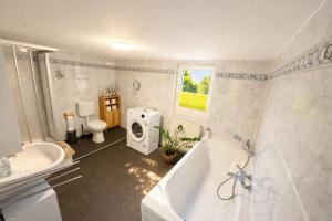 a bathroom with a tub and a sink and a toilet at Apartment-schiefe- Marie in Oberlungwitz