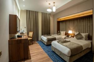 a hotel room with two beds and a flat screen tv at Hyksos Hotel in Erbil +82 photos