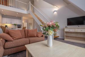 a living room with a couch and a vase of flowers at Strandnest in Dierhagen