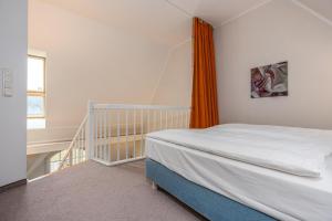 a bedroom with a bed and an orange curtain at Strandnest in Dierhagen