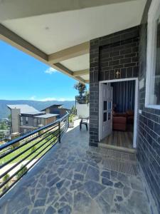 a balcony with a view of the mountains at Saffron 2 Bedroom Duplex Villa in Mukteshwar