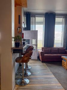 a living room with a couch and a table and chairs at Saffron 2 Bedroom Duplex Villa in Mukteshwar
