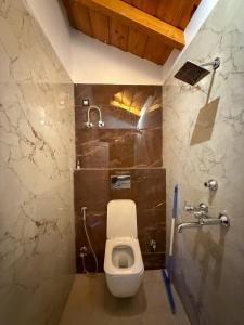 a bathroom with a white toilet and a shower at Saffron 2 Bedroom Duplex Villa in Mukteshwar +19 photos