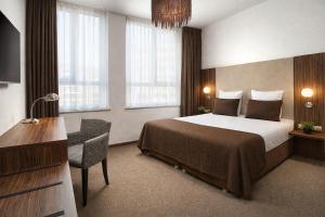 a hotel room with a bed and a desk at Hotel La Reine in Eindhoven