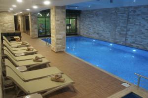 a pool in a hotel with a row of lounges around it at Sakarya Hotel in Sakarya