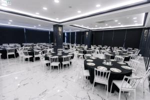a banquet hall with white tables and white chairs at Sakarya Hotel in Sakarya +45 photos