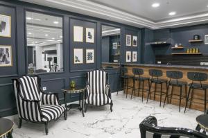 a bar with black and white chairs and a counter at Sakarya Hotel in Sakarya
