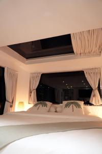 a bedroom with a large white bed with curtains at Hidden Valley GLAMPING in Fujairah