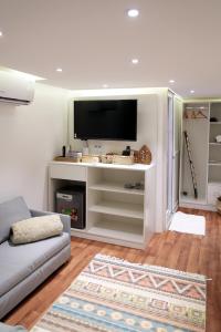 a living room with a couch and a tv at Hidden Valley GLAMPING in Fujairah