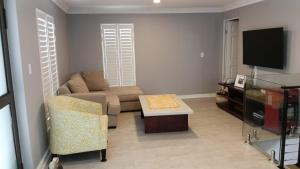 a living room with a couch and a table and a tv at Casa Mia in Jeffreys Bay
