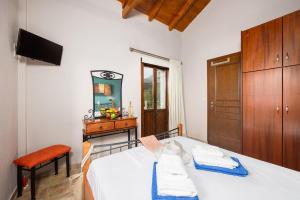 a bedroom with a white bed and a wooden cabinet at Panorama II Villas in Lévktron +30 photos