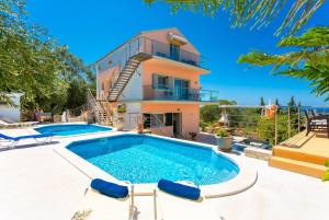 a villa with a swimming pool and a house at Villa Stephania in Gaios