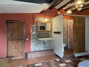a bathroom with a sink and a mirror and a door at Mas Costa in Sant Ferriol