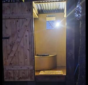a bathroom with a wooden door and a mirror at Ty Grug Retreat in Little Newcastle