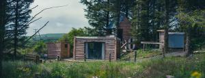 a small wooden cabin in the middle of a field at Ty Grug Retreat in Little Newcastle