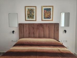 a bed in a bedroom with two pictures on the wall at Corazón Urbano in Martil