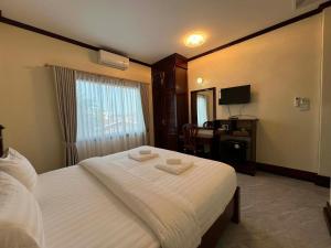 a hotel room with a bed with two towels on it at Skyview Hotel in Ban Donsôm Tai