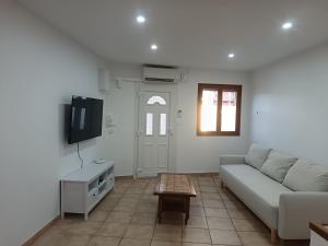 a living room with a couch and a tv at Maison le Flamant in Port-Saint-Louis-du-Rhône