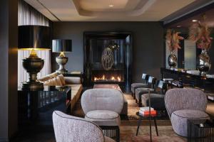 a waiting room with chairs and a fireplace at Roomers Frankfurt Central, Autograph Collection in Frankfurt